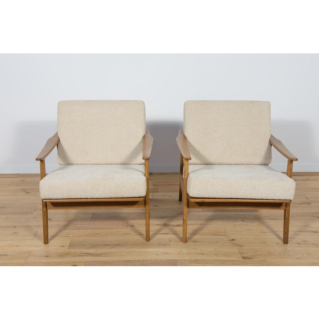 A pair of Model 5825 armchairs manufactured in the 1960s. Armchairs with a unique Scandinavian form. The armchairs have...