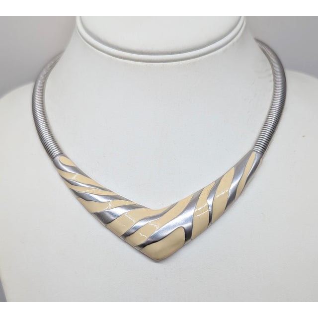 Rhodium plated ivory enamel zebra stripe v shaped collar necklace with fold over clasp. Marked "©MONET" on the back of the...