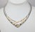 Rhodium plated ivory enamel zebra stripe v shaped collar necklace with fold over clasp. Marked "©MONET" on the back of the...