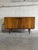 This minimalist low-profile credenza features a streamlined rectangular frame supported by dark tapered legs. The double...