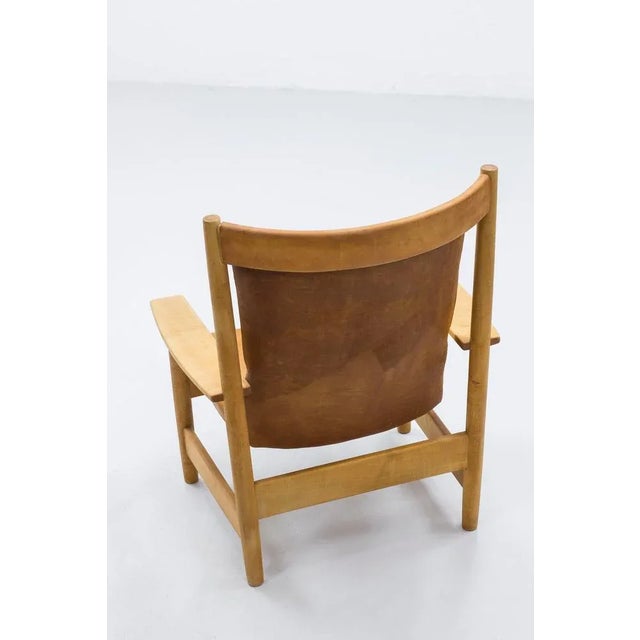 Large and powerful high back lounge chair from the Swedish Modern era. Made from solid beech wood with natural leather...