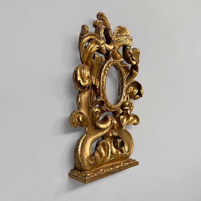 Italian giltwood frame with decorations, 1800s Carved and gilded wooden frame in the Baroque style, vertically oriented...