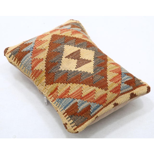 A one-of-a-kind handwoven Afghan wool kilim lumbar pillow featuring concentric diamond medallion. Cut and sewn by hand...
