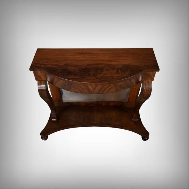 This elegant mahogany and mahogany burl veneer console table with a mirrored top captivates with the richness of its grain...