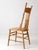 Antique pressback chair with a tall spindle back, turned details, and a pressed floral motif across the crest rail....