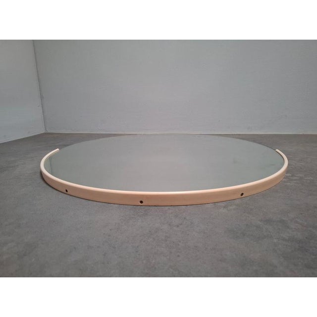 A distinctive vintage round wall mirror originating from Czechoslovakia and dating to circa 1970. The design features a...