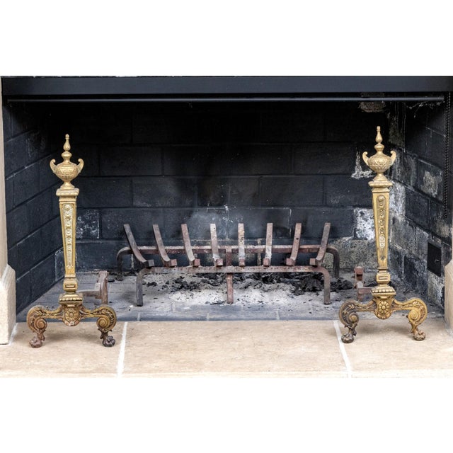 A pair of heavy neoclassical style antique brass andirons with urn form finials, rectilinear and tapered post, cabriole...