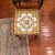 Beautiful set of three French Provincial-style nesting tables featuring intricate gold floral designs, cream-colored tops,...