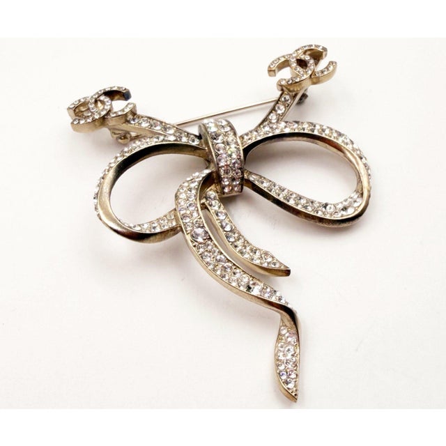 Chanel Gold CC Bow Ribbon Crystal Brooch *Marked 10 *Made in France *Comes with the original box - It is approximately...