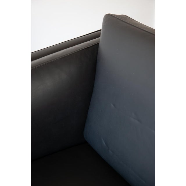 A sweet two-seater sofa in soft black leather which was made in Denmark around the 1970s, in the style of Borge Mogensen....