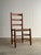Antique ladderback chair with three shaped slats, turned posts, and hand-woven rush seat. Solid wood frame with...