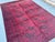 This bold Ersari rug features a two-column grid of large octagonal medallions, each centered with an open solid-color...