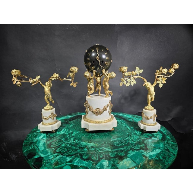 Materials: Gilt bronze and Carrara white marble Style: 19th Century French Features: Representation of cherubs holding the...