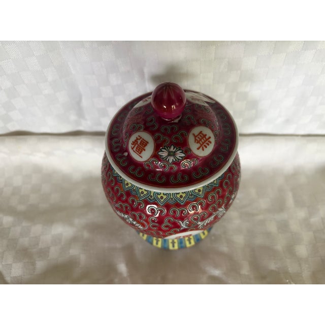 A Vintage Red Mun Shou Longevity Ginger Jar. The piece has a slightly raised enameled finish and bears longevity symbols....