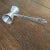 French nickel silver double jigger with a etched handle that reads Measure on both sides at the end of the handle. The...
