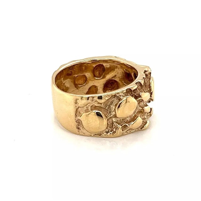 This is a vintage wide band ring, it is crafted from 14k yellow gold featuring and front half with the nugget style. The...