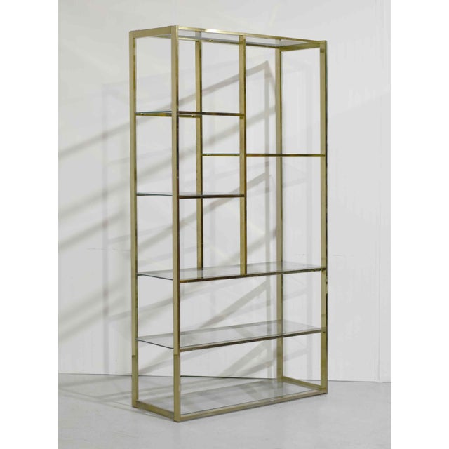 Sleek, glamorous, and architecturally striking, this mid-century étagère features a gold chrome frame paired with glass...