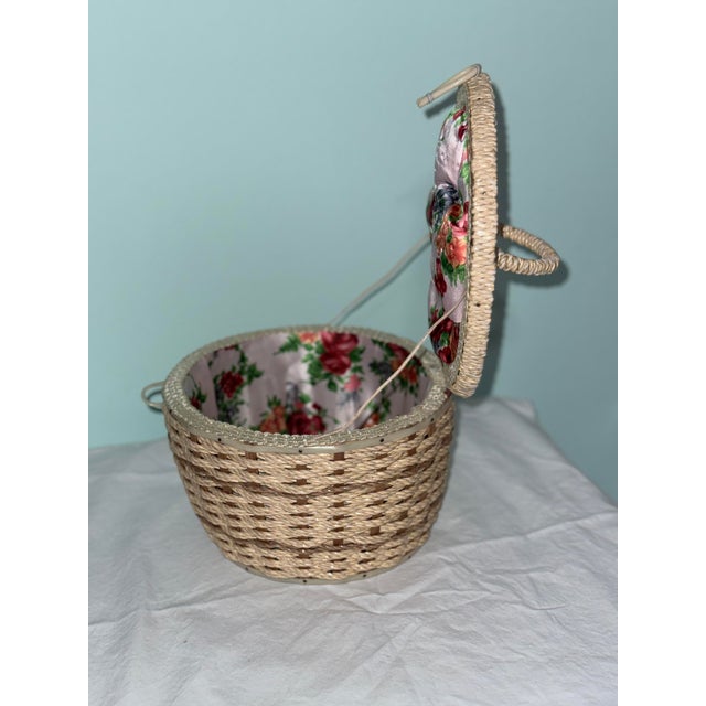 Charming vintage wicker sewing basket featuring a beautiful floral fabric-covered lid and original woven handle. This...