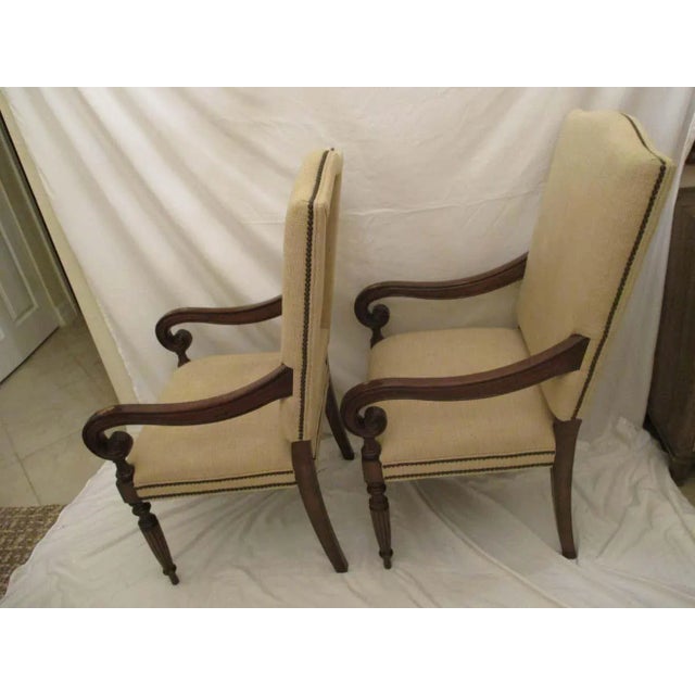 Pair of dark stained upholstered club chairs with original neutral upholstery in good condition. Chairs have nailhead trim...