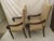 Pair of dark stained upholstered club chairs with original neutral upholstery in good condition. Chairs have nailhead trim...