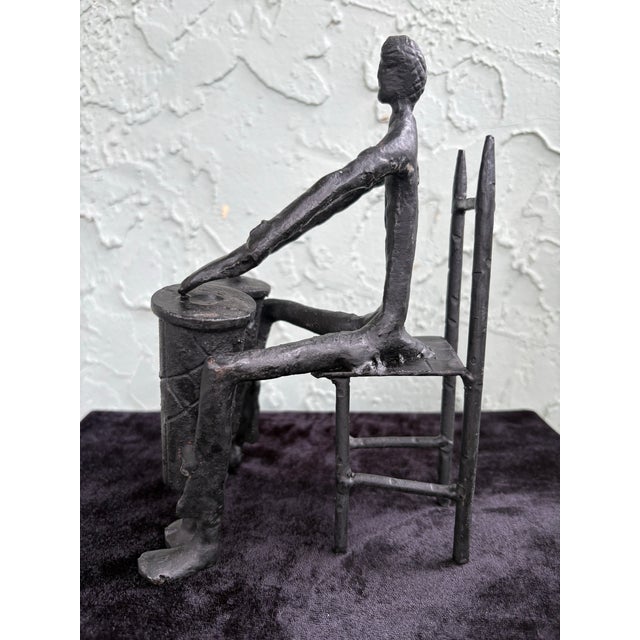 This striking mid-century modern abstract metal sculpture depicts a stylized seated figure engaged in a rhythmic, almost...