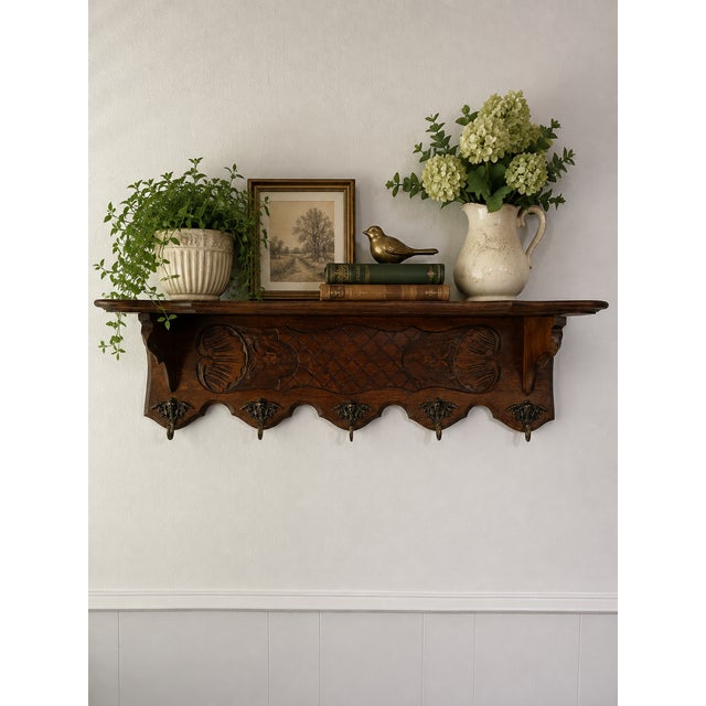 A superb antique carved wood French Wall Coat and Hat Rack with Shelf in a rich dark stain, circa Early 20th Century. This...