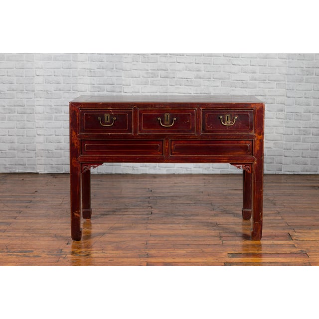 A Chinese antique console table from the early 20th century, with three drawers and carved spandrels. Crafted in China,...