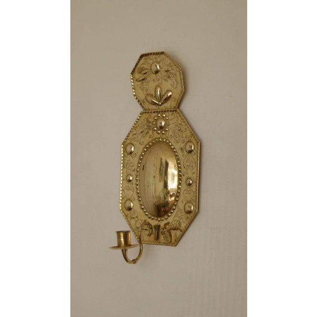 Pair of brass sconces are Swedish Baroque-style wall reflectors featuring repoussé decorative details Both sconces are in...