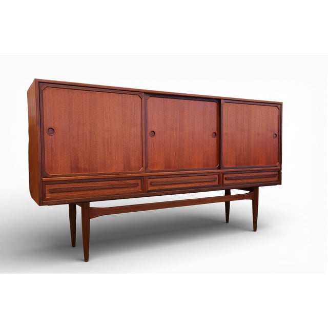 A fantastic Danish cabinet with sliding doors and drawers in teak and walnut! The cabinet has three sliding doors that...