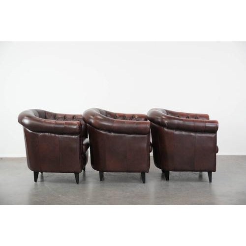 Offered is this set of three classic English-style Chesterfield club chairs in cowhide leather, finished with decorative...