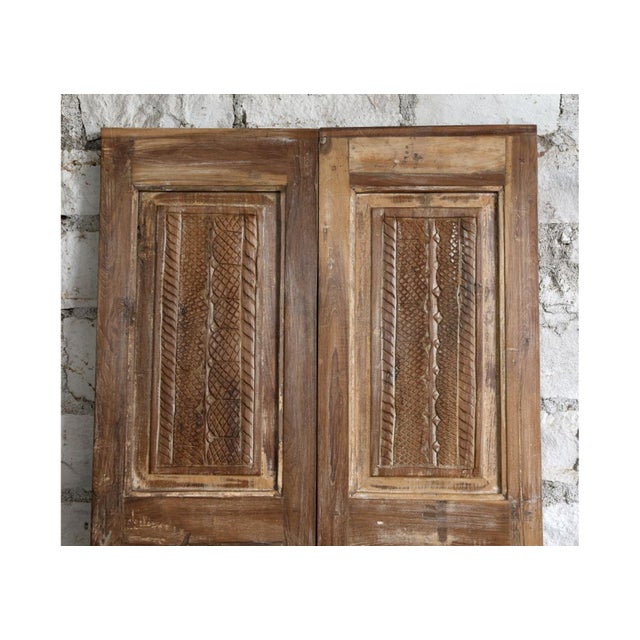 Elevate your interior with this hand-carved sliding double door, beautifully crafted from reclaimed wood and rich with...