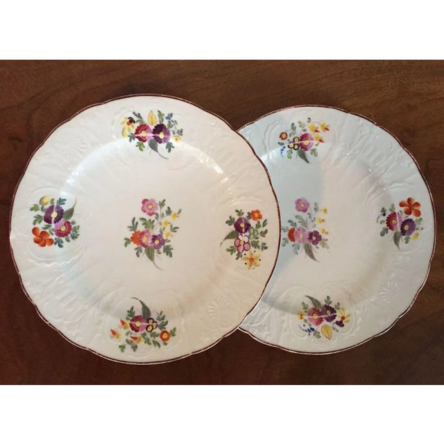 Pair Coalport dishes dating from the early 19th century. Each has relief molded ground and is decorated with polychrome...