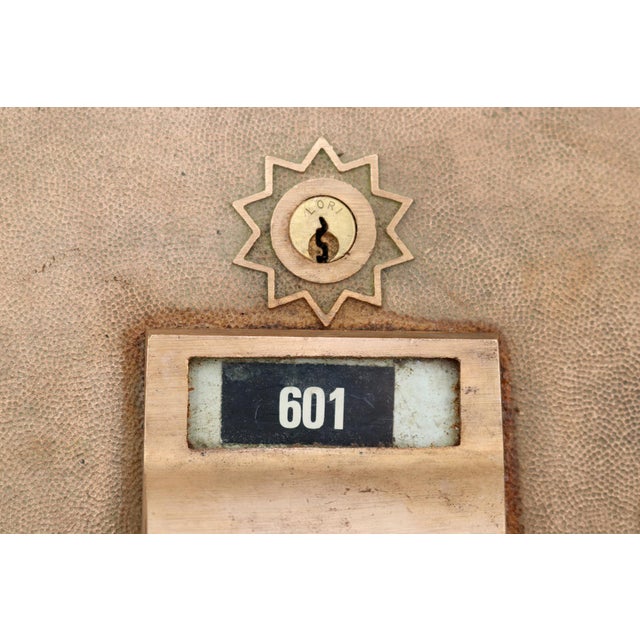 Vintage brass U.S. Post Office mailbox door with a Greek key pattern and a window plate displaying the box number 601....