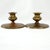 A pair of substantial, low-profile brass candlesticks featuring a rich, naturally aged patina with distinct golden and...