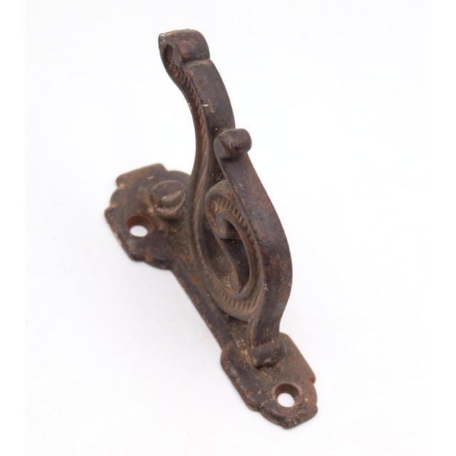 Antique Art Deco style hook made of cast iron with a black finish. The original mounting screws are not available. Good...