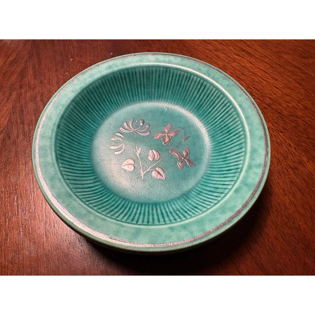 This stunning ceramic turquoise stoneware bowl has applied designs of flowers and leafs and was designed by Wilhelm Kåge...