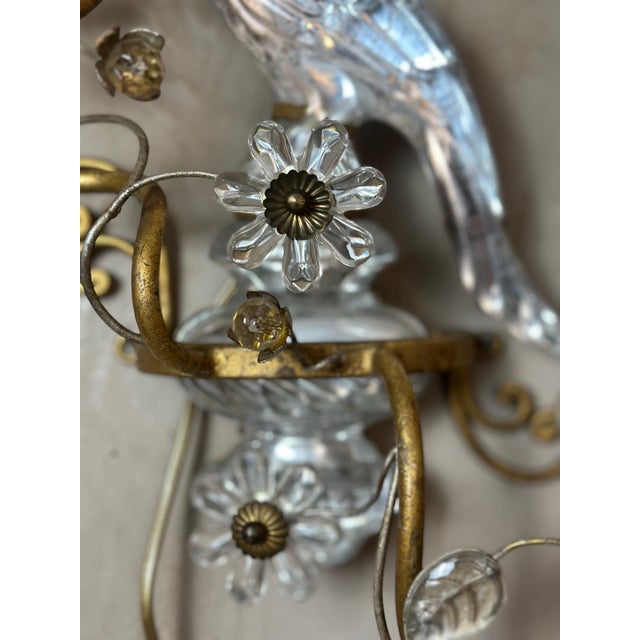 An elegant pair of wall sconces by the renowned French firm Baguès, emblematic of 20th-century decorative craftsmanship....