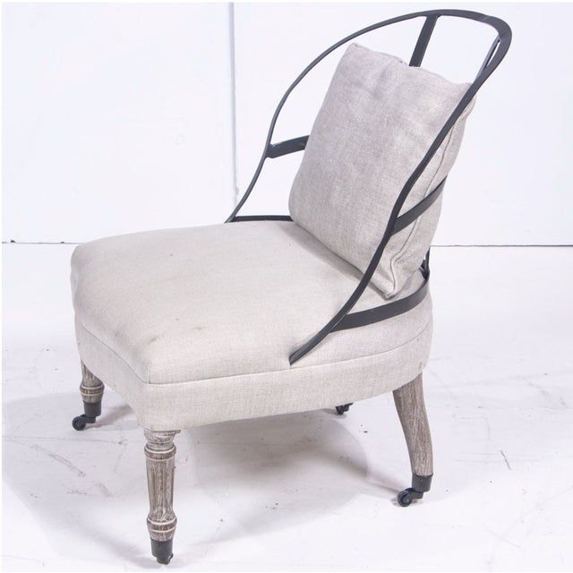 A Restoration Hardware (RH) Couturier's chair, the exposed metal frame back over shaped linen upholstered seat, raised on...