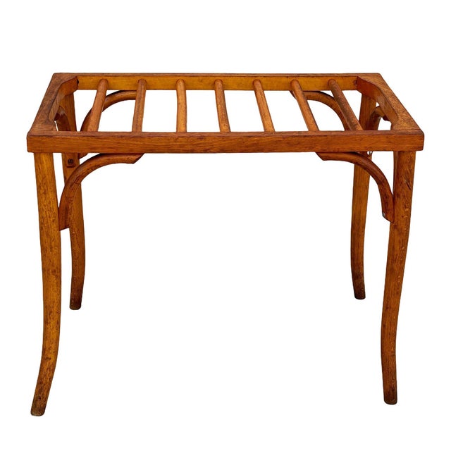 This early 20th-century bentwood luggage rack features a rectangular slatted top supported by four slender, gently splayed...