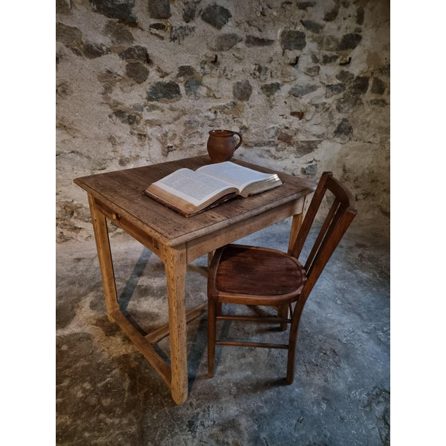 This rustic French farmhouse table was crafted from solid oak around 1900. The piece features a natural, time-worn patina...
