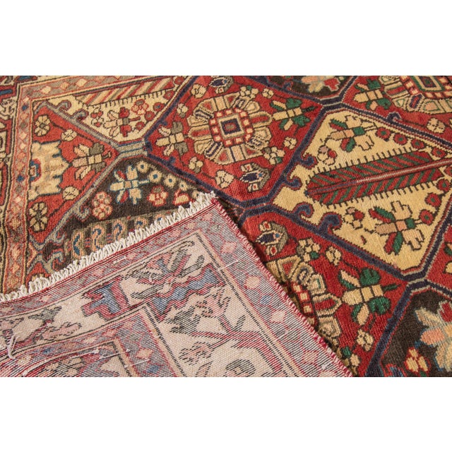 Beautiful hand-knotted wool, vintage Persian Bakhtiari rug. This rug has a red field with beige accents in an all over...