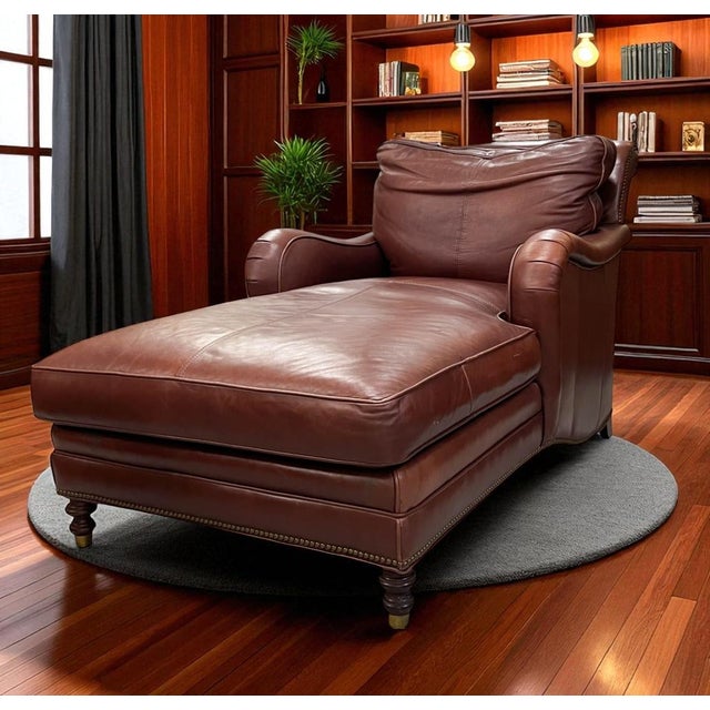 This elegant leather chaise lounge is upholstered in rich, reddish-brown top-grain leather that displays a beautiful...