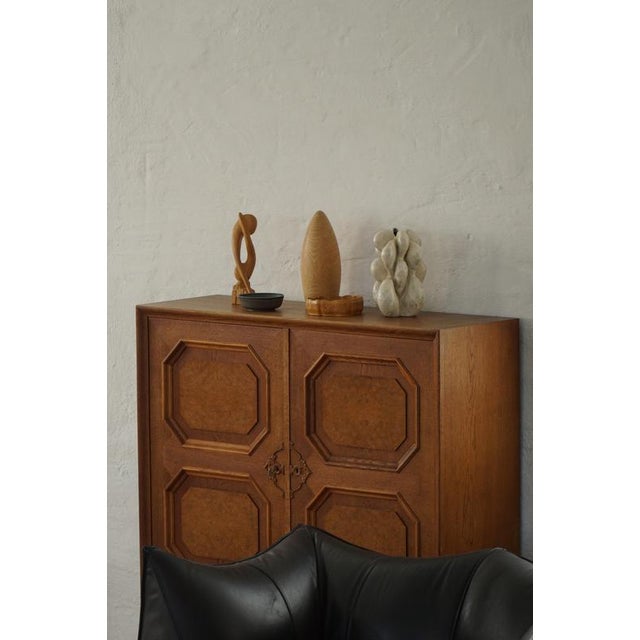 A refined Dansih cabinet crafted in oak with decorative burl wood veneer panels, dating to the 1940s-1950s. The facade...