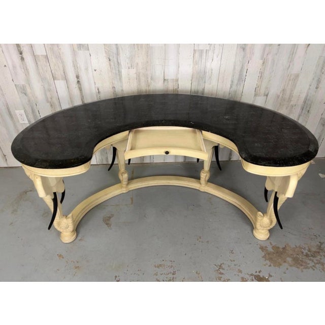 Hand carved wooden elephants holding pineapples in their trunks painted in an antique cream color, on top the tessellated...