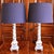 Encircled by grape vines, these Neoclassical hand painted wooden columnar lamps have solid articulated and moulded block...