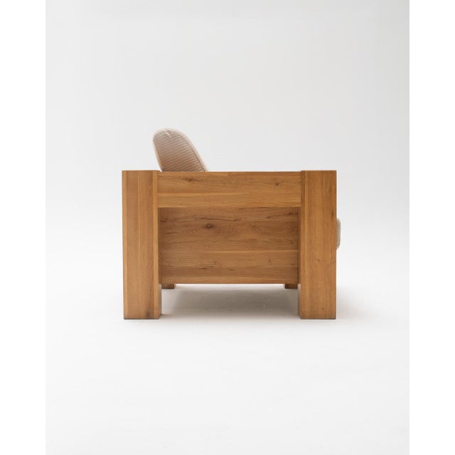 Mid-century modern armchair with a solid oak frame, inspired by 1970s Italian design. The piece is characterized by its...
