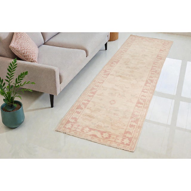 This is a vintage Turkish Oushak rug from the Mid 20th Century. The piece was hand-knotted.