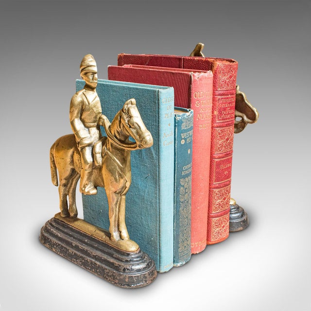 This is a pair of antique mounted horse rider bookends. An English, polished bronze and cast iron figural book rest,...