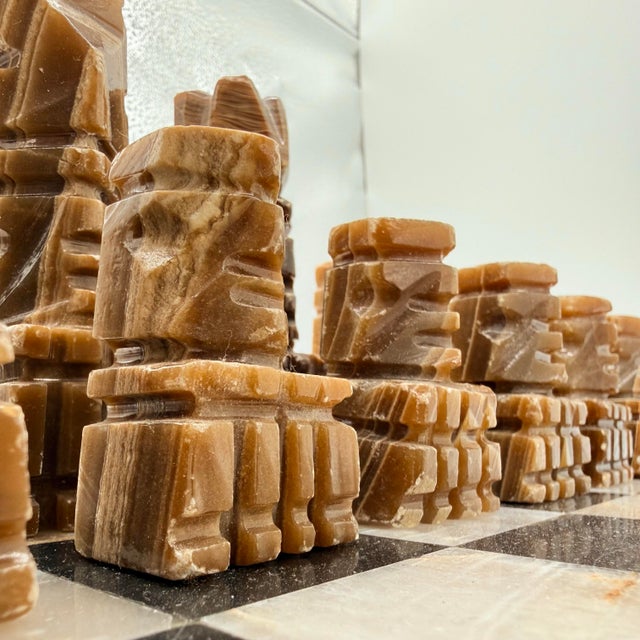 A chess set that reads more like sculpture. This vintage carved stone set pairs warm espresso and honey-banded pieces with...