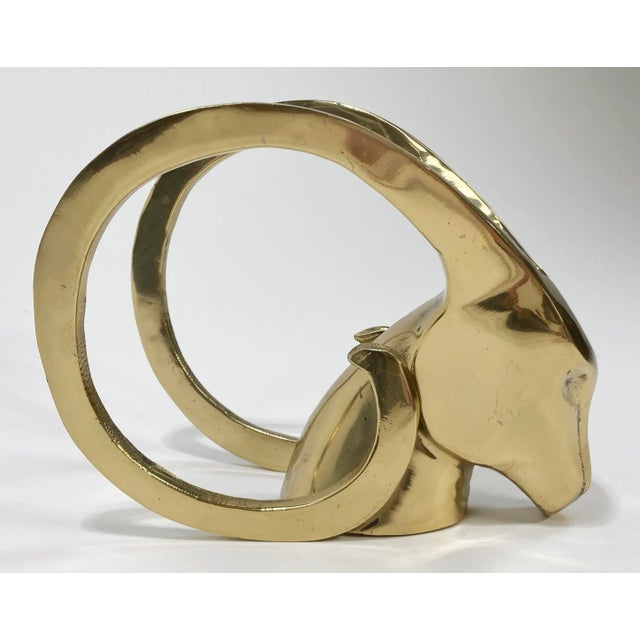 Vintage stellar brass mid century modern style rams head bookend or decorative accessory. Circa 1980s. Patina.